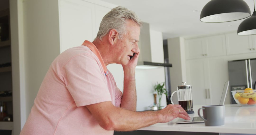 Caucasian senior man sitting in kitchen with coffee and having call - Free Images, Stock Photos and Pictures on Pikwizard.com