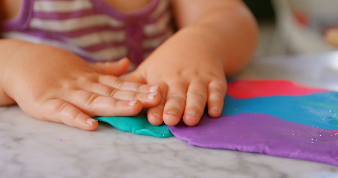 Close-Up of Toddler Playing with Colorful Clay at Home