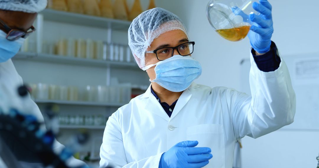 Scientist examining sample in laboratory with protective gear - Free Images, Stock Photos and Pictures on Pikwizard.com