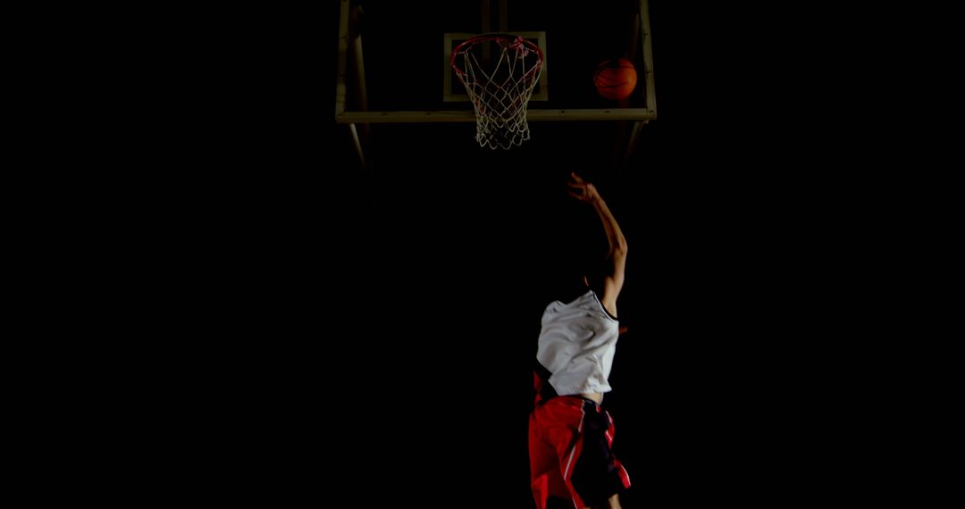 Basketball Player Dunking in Dark Arena - Free Images, Stock Photos and Pictures on Pikwizard.com