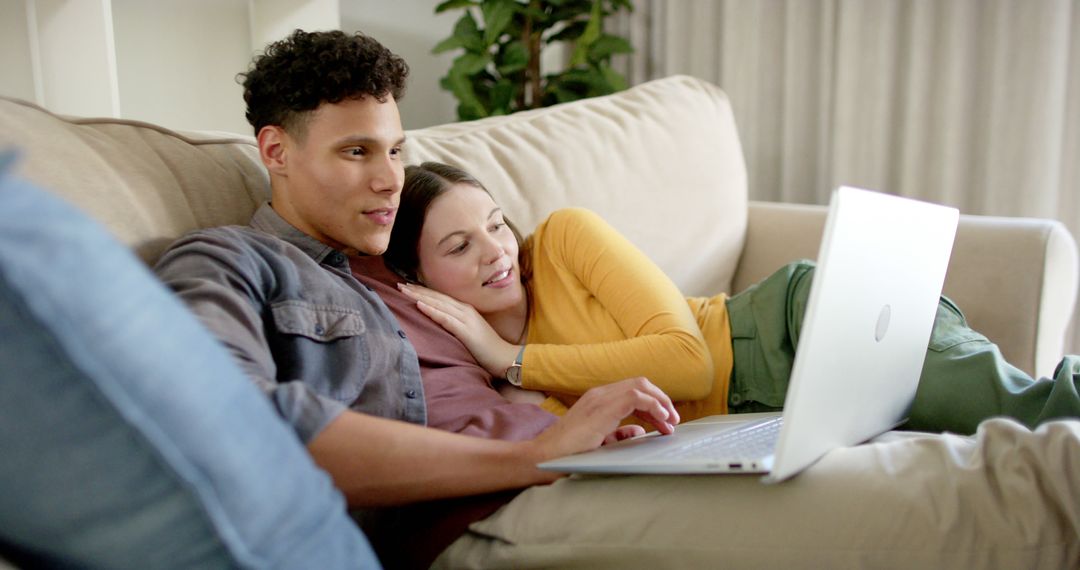 Happy Couple Relaxing on Sofa Together Using Laptop