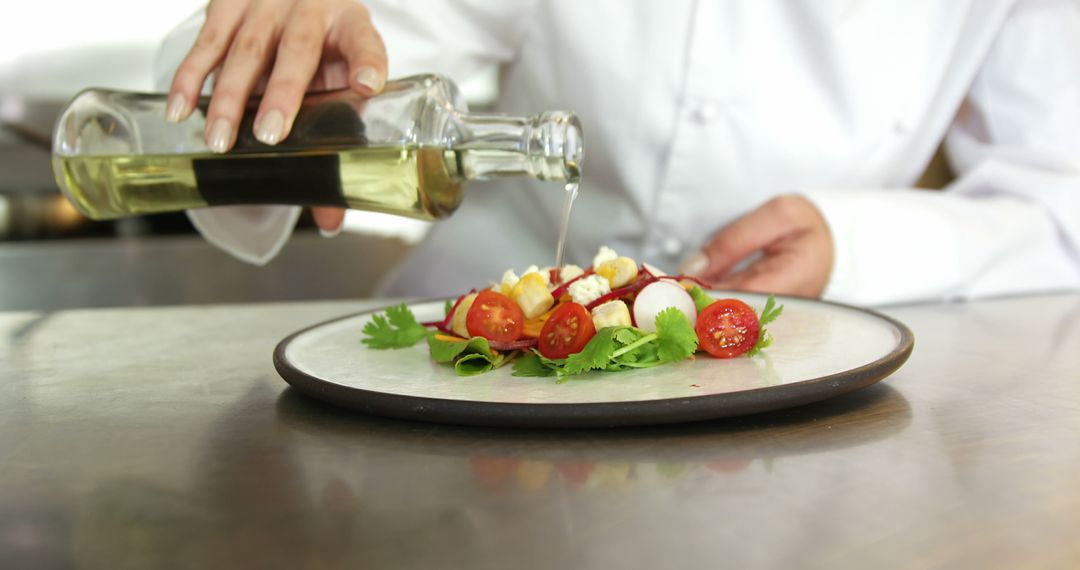 Chef Adding Olive Oil to Fresh Salad with Tomatoes and Herbs - Free Images, Stock Photos and Pictures on Pikwizard.com