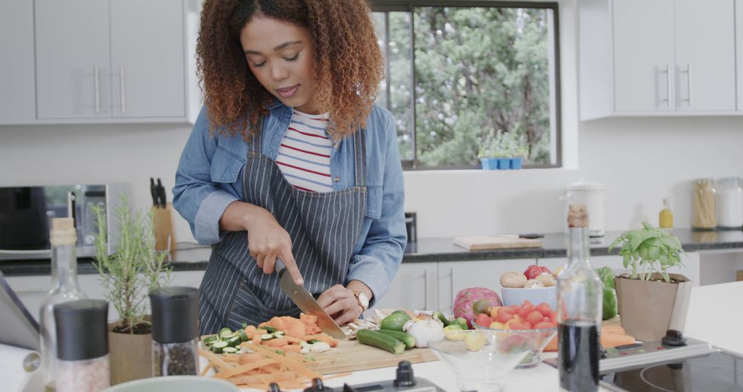 Young African American Woman Chopping Vegetables in Modern Kitchen - Free Images, Stock Photos and Pictures on Pikwizard.com