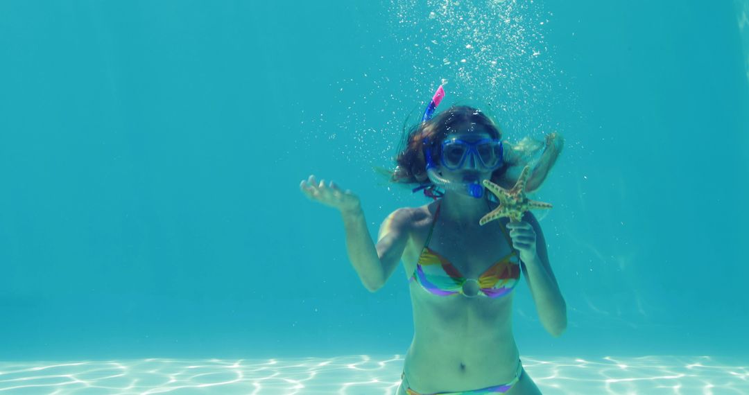 Young Woman Snorkeling in Pool with Starfish and Bubbles - Free Images, Stock Photos and Pictures on Pikwizard.com