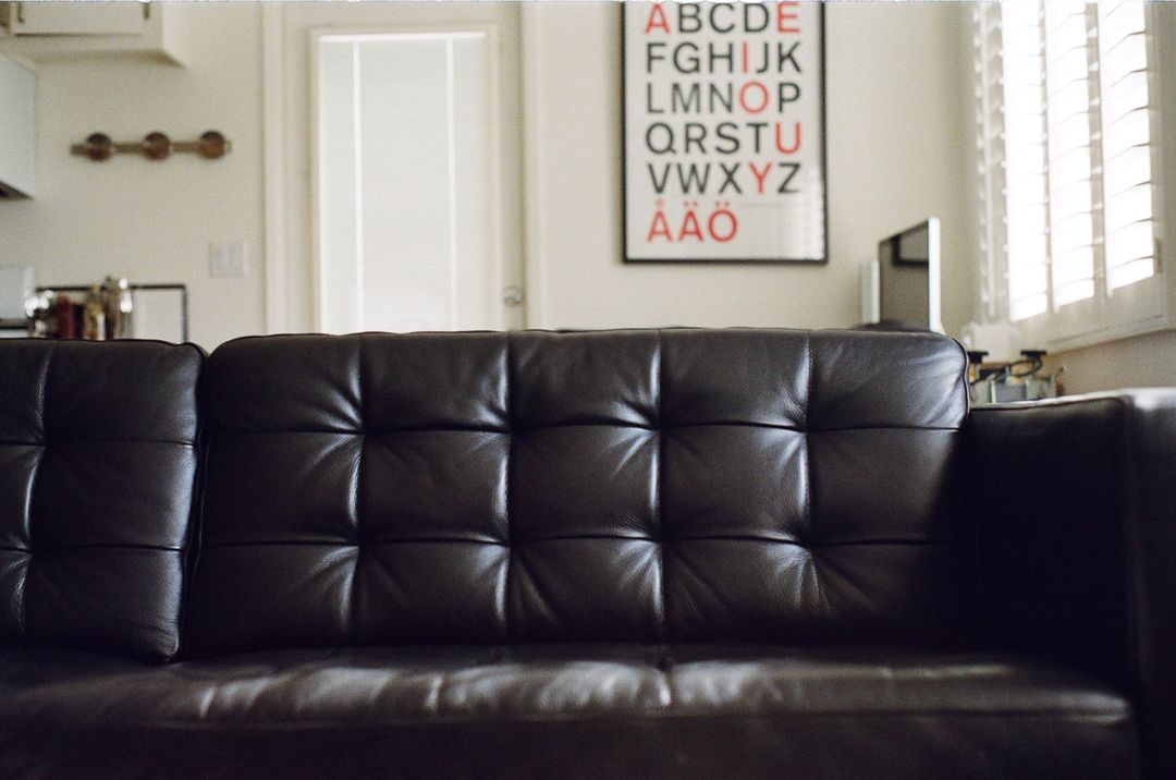 Modern Living Room with Black Leather Sofa and Typography Wall Art - Free Images, Stock Photos and Pictures on Pikwizard.com