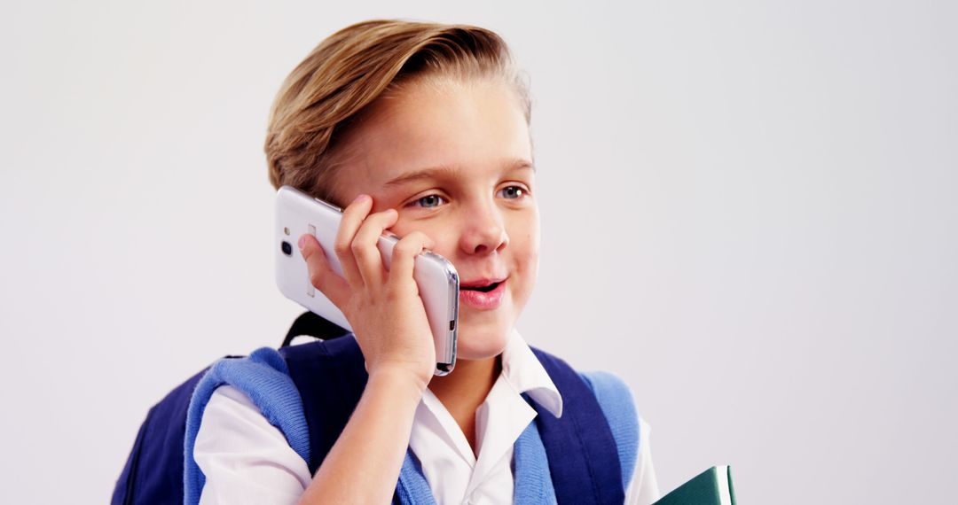 Smiling Schoolboy Talking on Smartphone in Uniform
