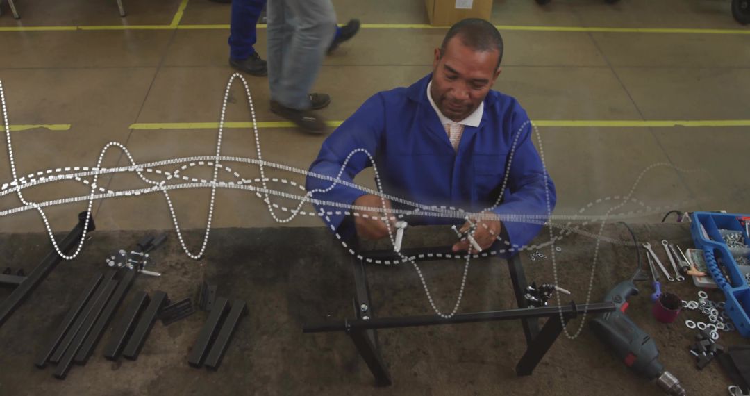 Assembling mature factory technician fastening metal frame on workbench in workshop