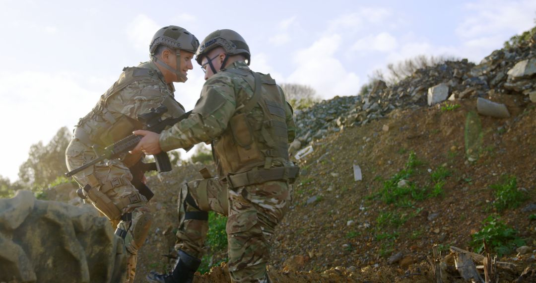 Two Soldiers Aiding Each Other During Military Training in Rugged Terrain - Free Images, Stock Photos and Pictures on Pikwizard.com