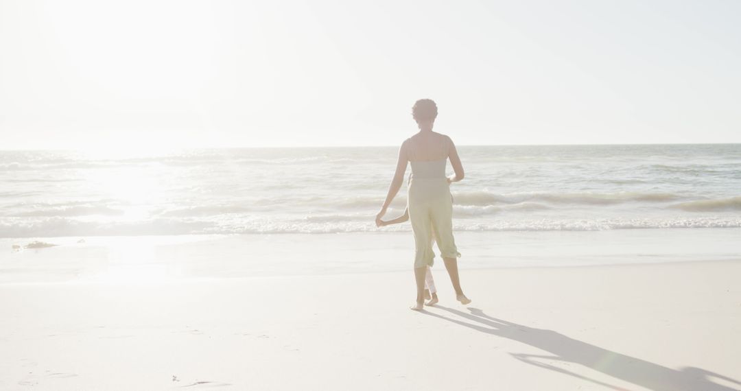 Woman Walking on Beach in Bright Sunlight - Free Images, Stock Photos and Pictures on Pikwizard.com