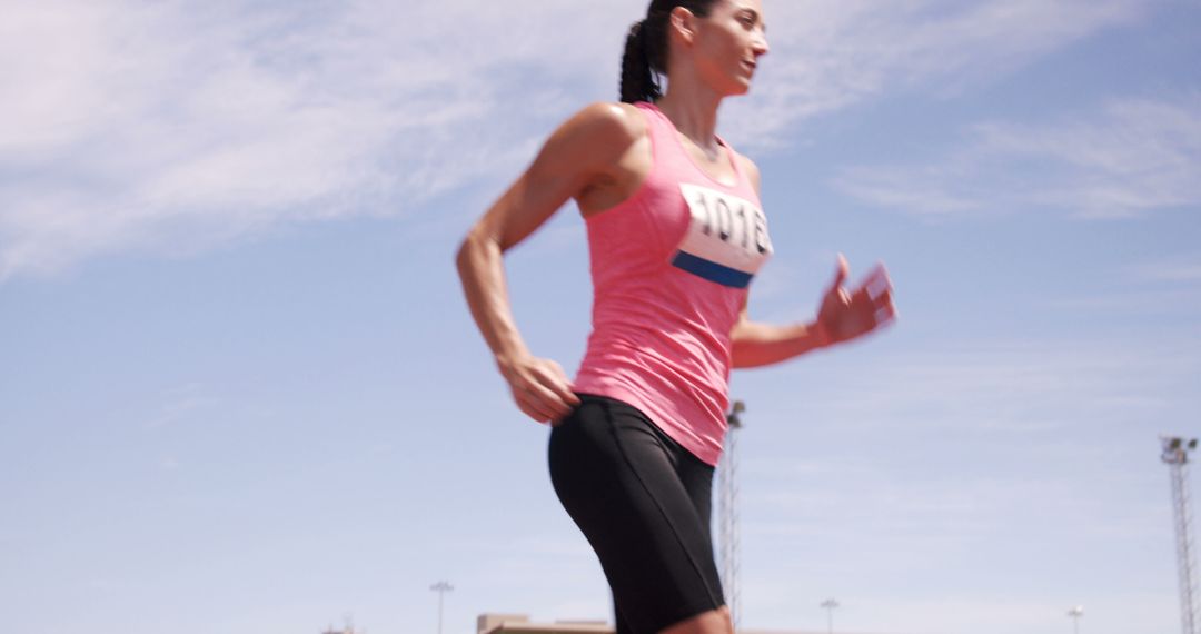 Female Athlete Running in Competition Under Blue Sky - Free Images, Stock Photos and Pictures on Pikwizard.com