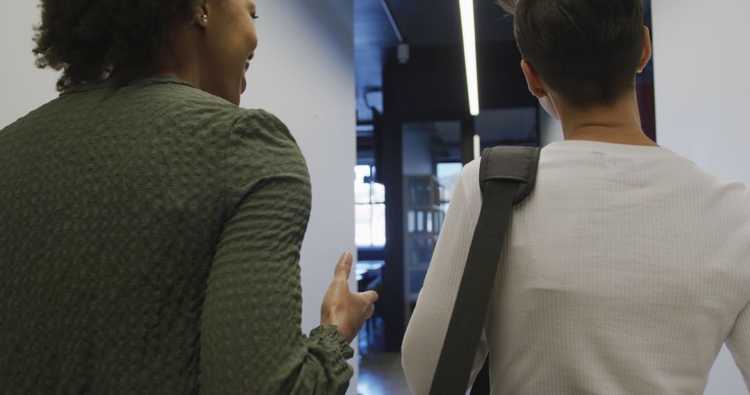 Diverse Professionals Discussing Work While Walking Through Office Corridor