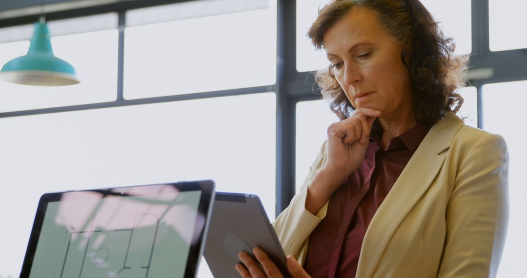 Mature Businesswoman Analyzing Data on Digital Tablet in Modern Office - Free Images, Stock Photos and Pictures on Pikwizard.com