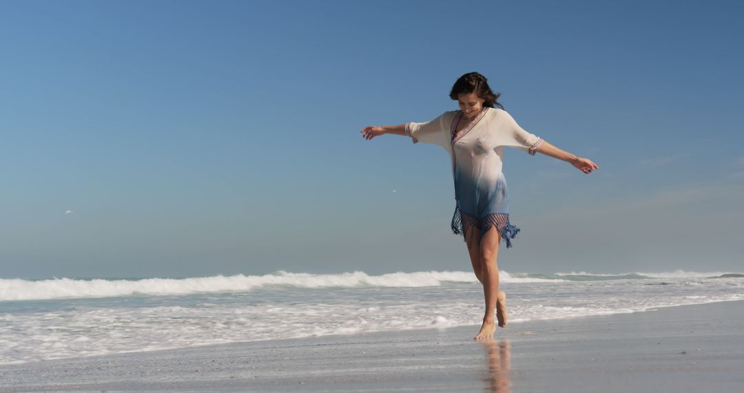 Woman Walking Along Sandy Beach with Waves - Free Images, Stock Photos and Pictures on Pikwizard.com