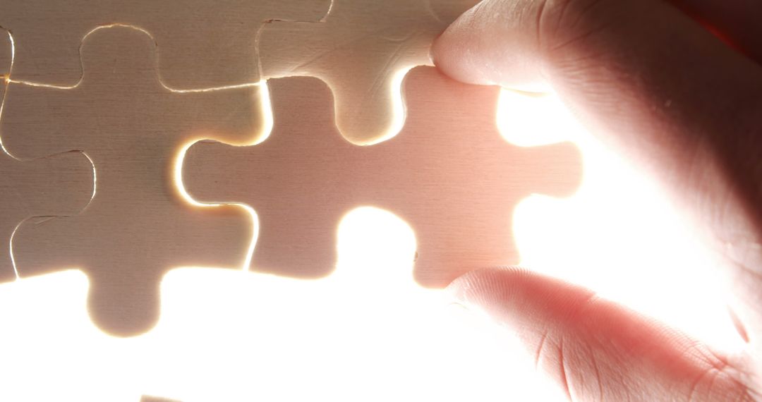 Close-up Hand Placing Puzzle Piece Into Place Symbolizing Solution