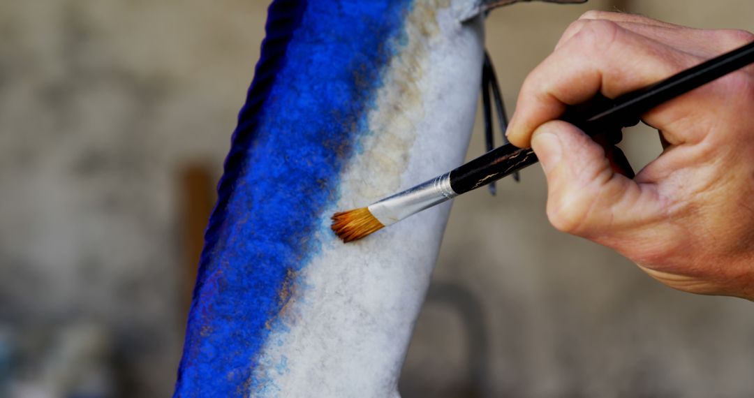 Artist Painting Detailed Blue Strokes on Fish Sculpture - Free Images, Stock Photos and Pictures on Pikwizard.com