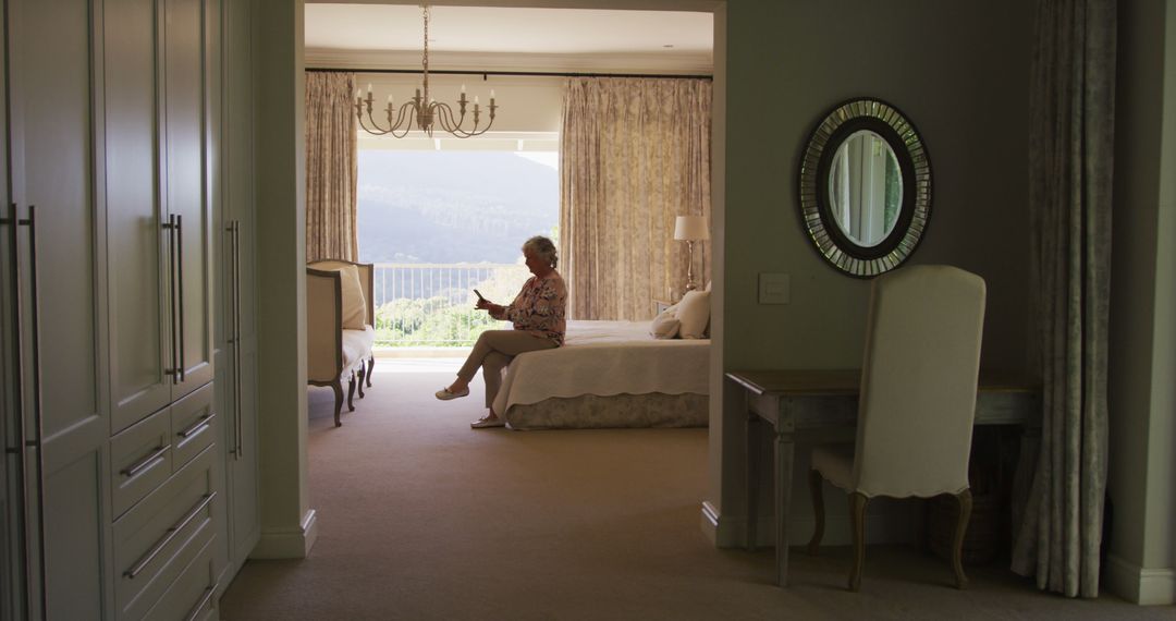 Senior Woman Sitting in Elegant Bedroom Interior - Free Images, Stock Photos and Pictures on Pikwizard.com