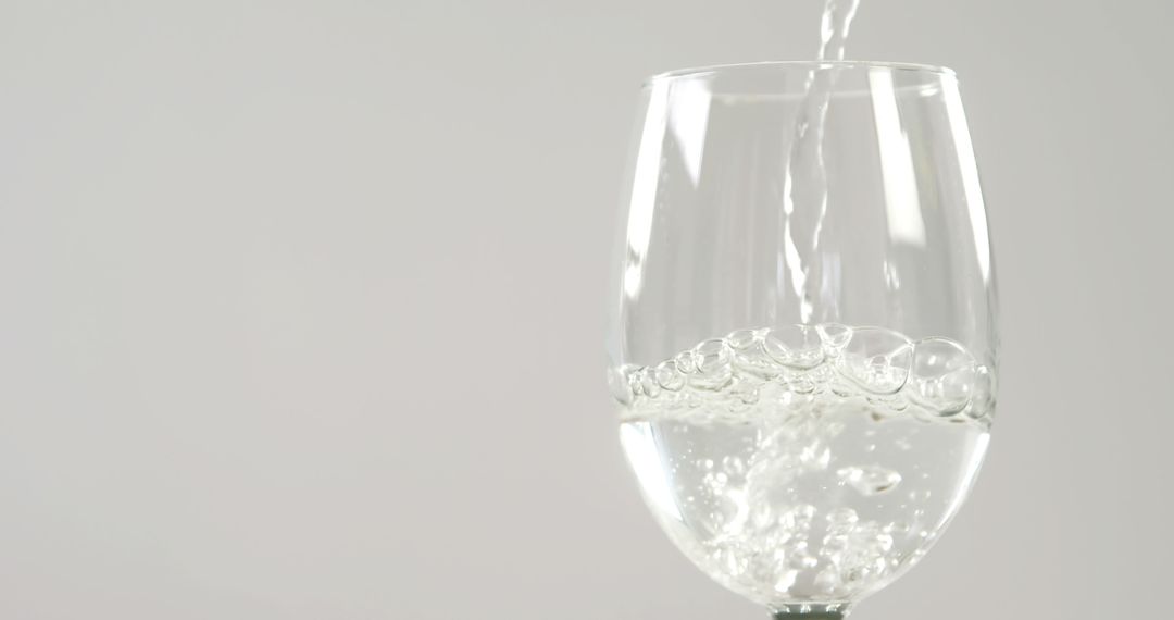 Pouring Sparkling Water into Wine Glass on White Background - Free Images, Stock Photos and Pictures on Pikwizard.com