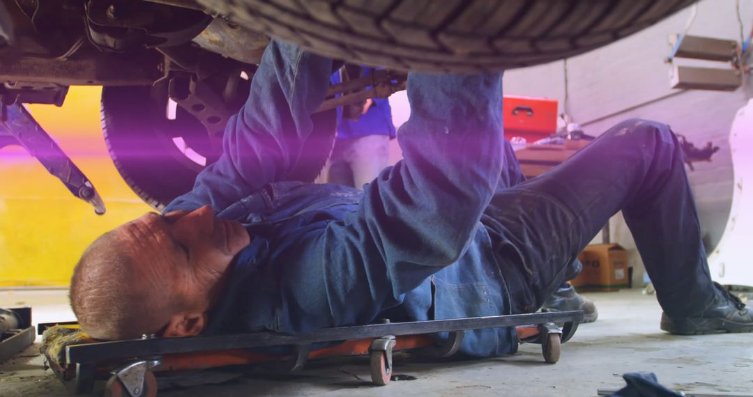 Mechanic Repairing Car Underbody in Workshop - Free Images, Stock Photos and Pictures on Pikwizard.com