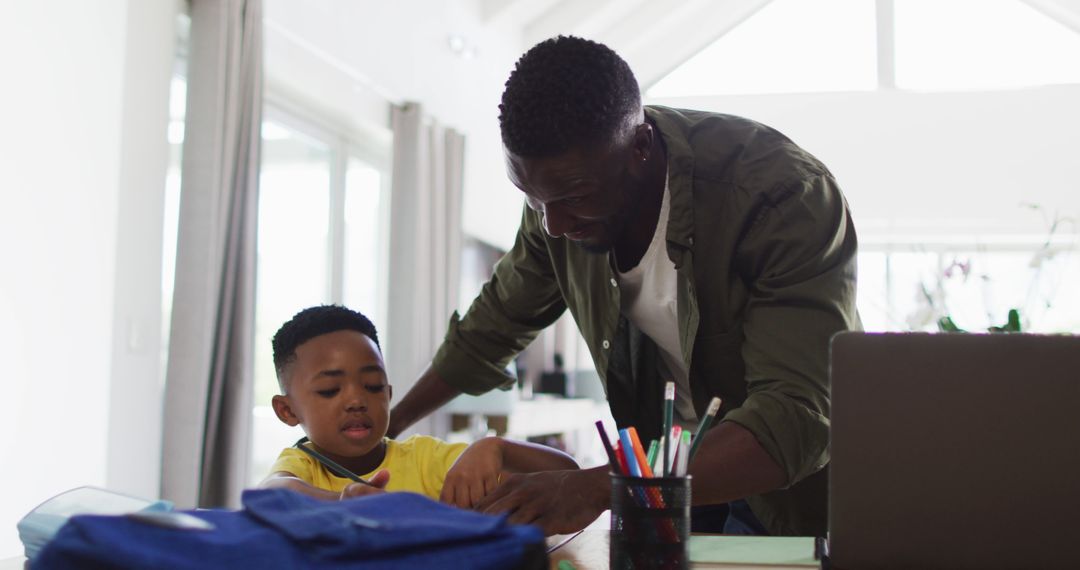 African American father helping son with homework at home - Free Images, Stock Photos and Pictures on Pikwizard.com