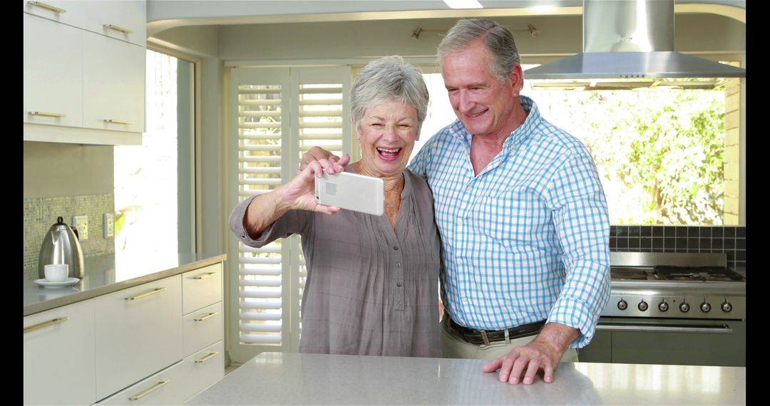 Senior Couple Taking Selfie in Modern Kitchen with Happy Expressions - Free Images, Stock Photos and Pictures on Pikwizard.com