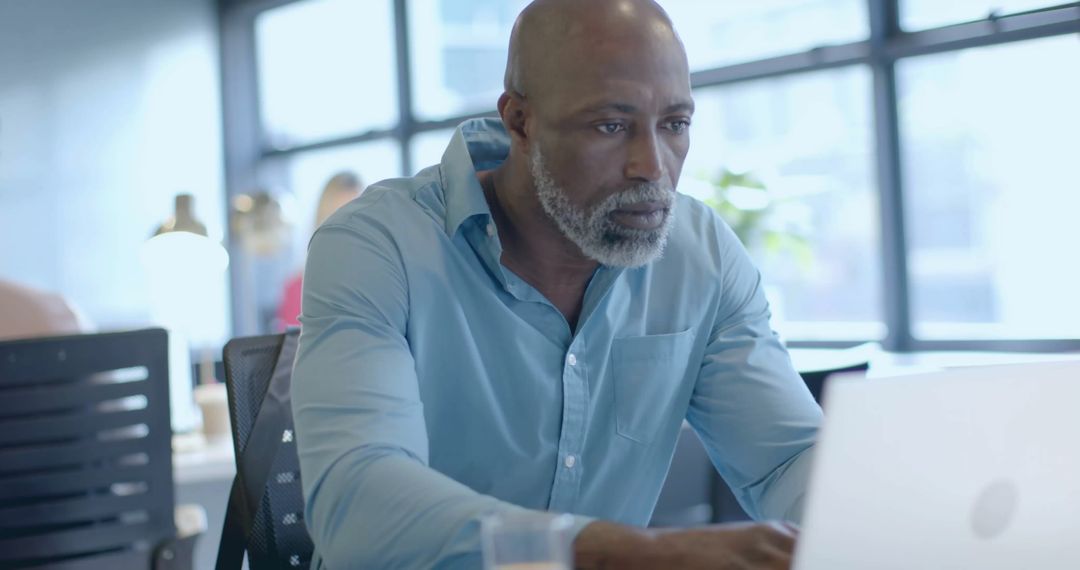 African American Businessman Analyzing Financial Data at Office Workspace