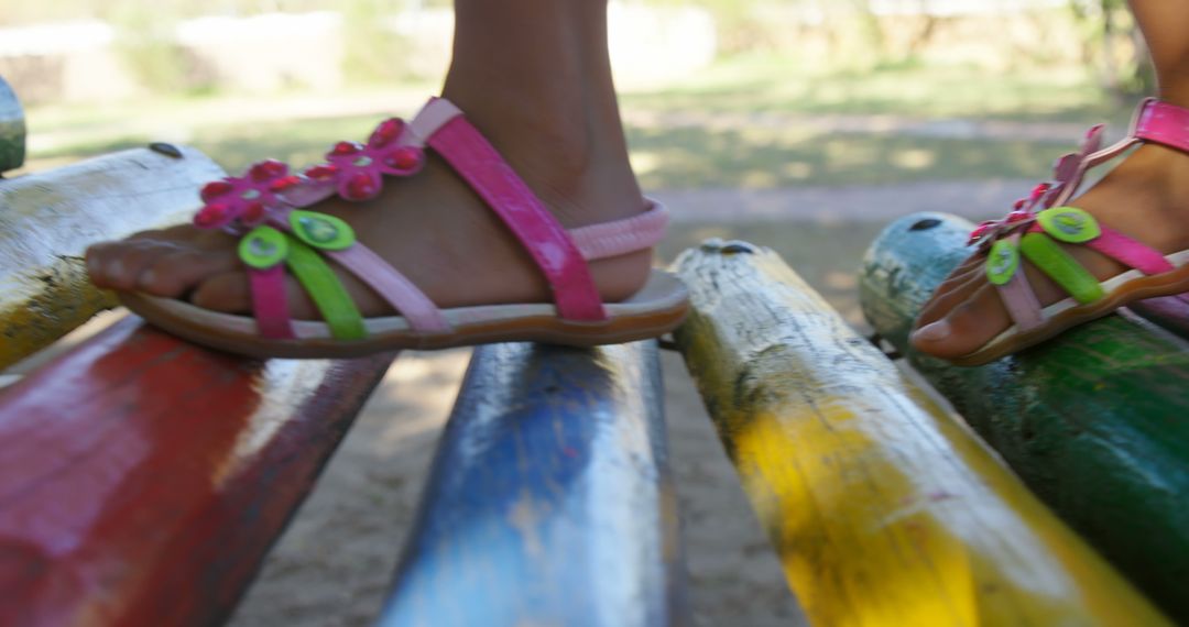 Close-Up of Child Walking on Colorful Wooden Beam in Sandals - Free Images, Stock Photos and Pictures on Pikwizard.com