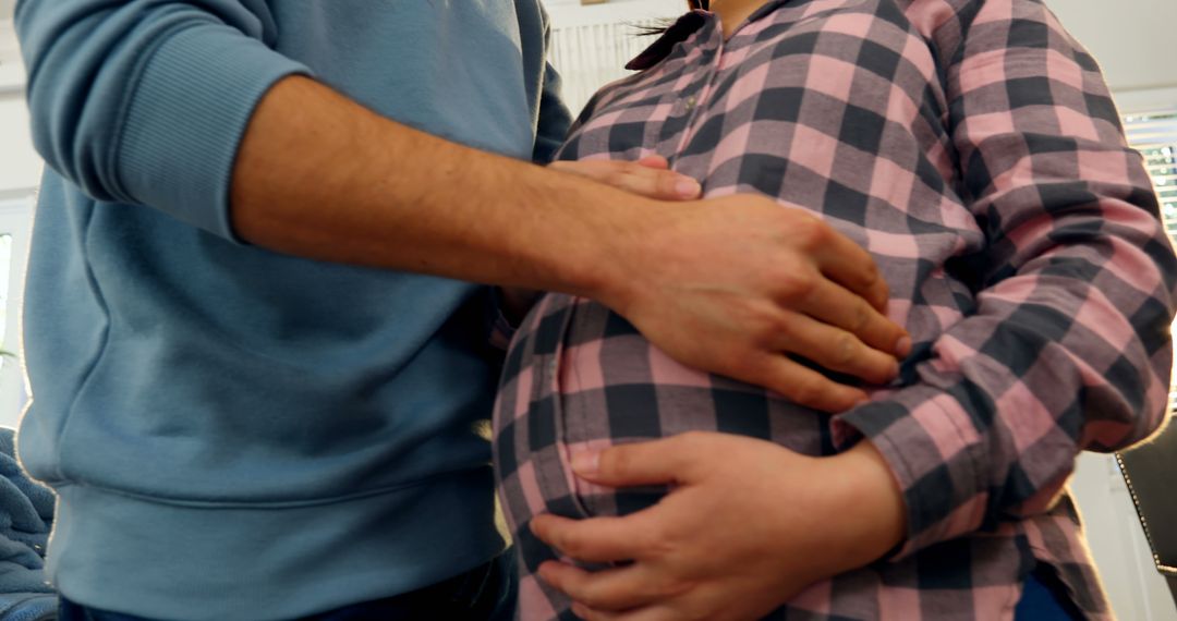 Close Up of Pregnant Woman and Partner Embracing Stomach in Home Setting - Free Images, Stock Photos and Pictures on Pikwizard.com