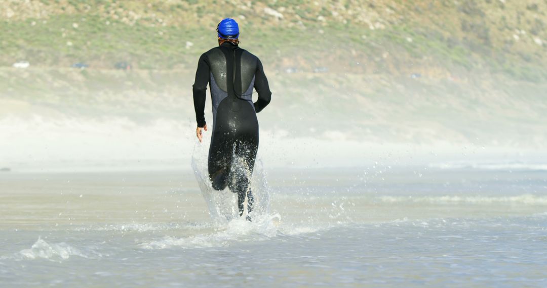 Triathlon Athlete Running Through Water on Beach - Free Images, Stock Photos and Pictures on Pikwizard.com