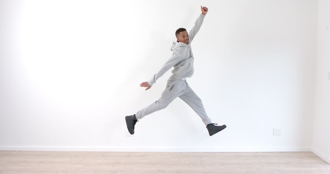 Energetic Man Leaping in Minimalist Space