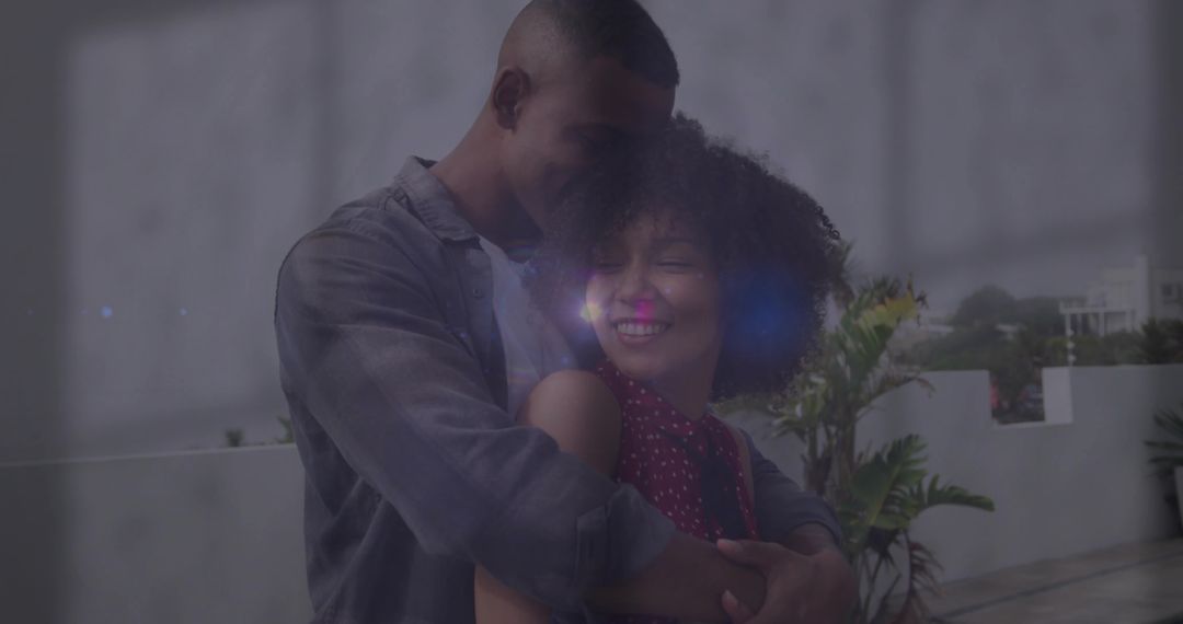 Romantic Couple Embracing on Urban Terrace with Lens Flare