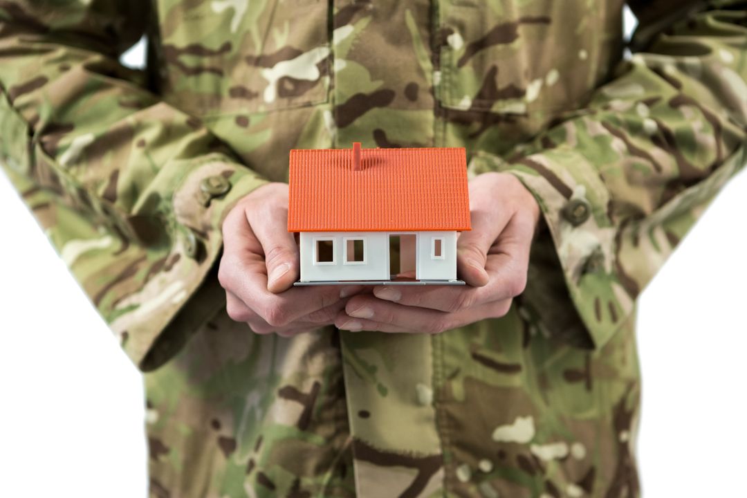 Mid section of soldier holding a model home - Free Images, Stock Photos and Pictures on Pikwizard.com