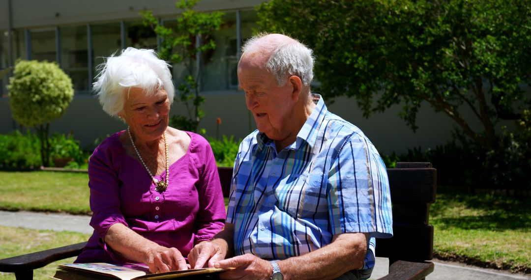 Senior Couple Reminiscing with Photo Album in Garden