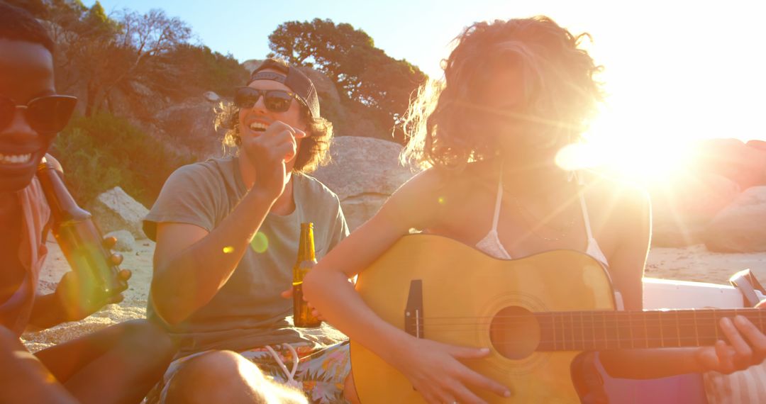 Friends Relaxing at Beach Playing Guitar During Sunset - Free Images, Stock Photos and Pictures on Pikwizard.com