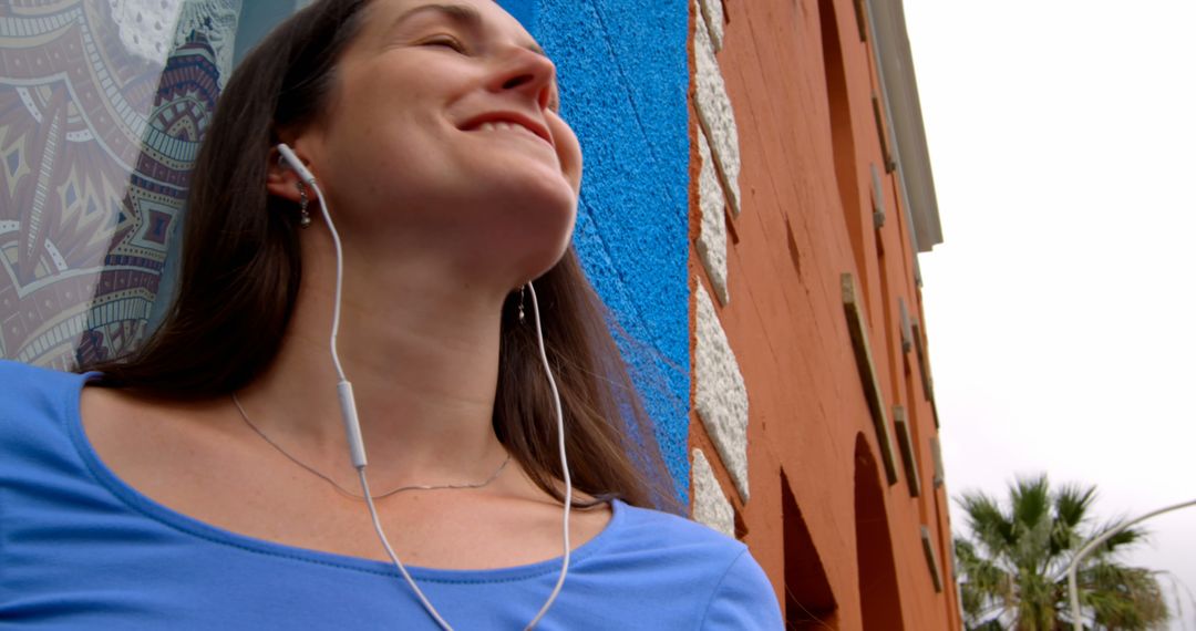 Woman Enjoying Music with Earphones Outdoors - Free Images, Stock Photos and Pictures on Pikwizard.com