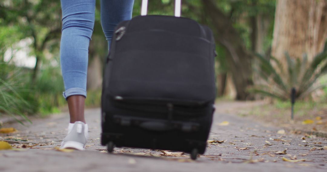 Traveler Pulling Suitcase Outdoors on Path - Free Images, Stock Photos and Pictures on Pikwizard.com