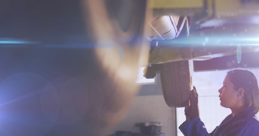 Female Mechanic Checking Wheel Alignment in Workshop