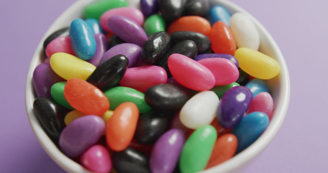 Bowl of Colorful Jelly Beans on Light Purple Background - Free Images, Stock Photos and Pictures on Pikwizard.com