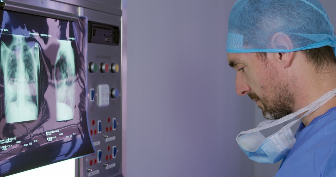 Doctor Examining Chest X-rays Under Blue Light in Clinical Setting - Free Images, Stock Photos and Pictures on Pikwizard.com