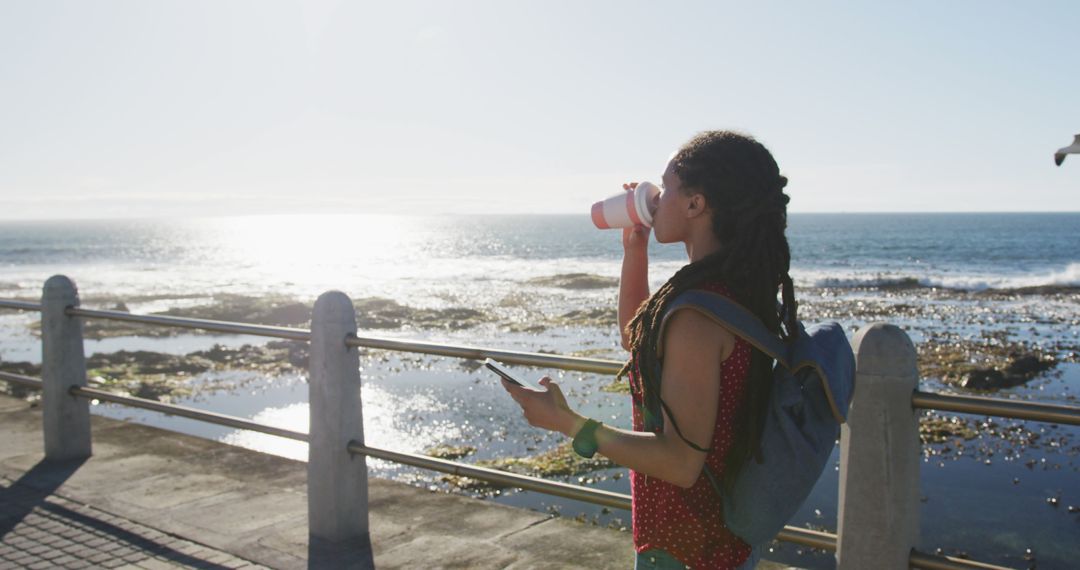 Young Woman Drinking Coffee by Sea - Free Images, Stock Photos and Pictures on Pikwizard.com