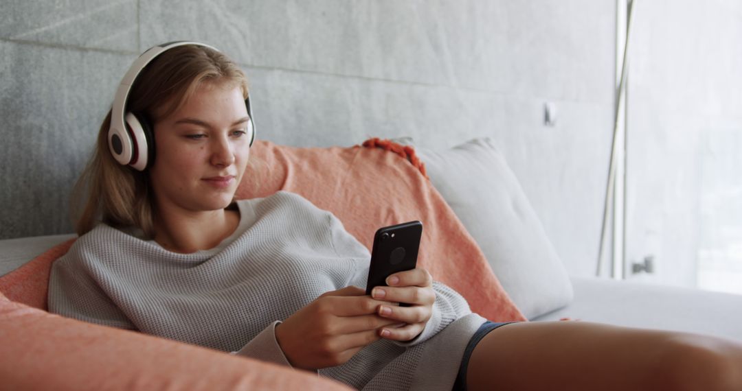 Young Woman Relaxing on Couch with Headphones and Smartphone - Free Images, Stock Photos and Pictures on Pikwizard.com