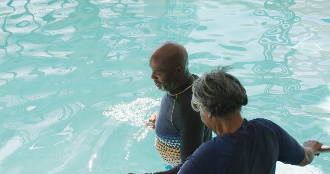 Elderly Couple Enjoying Swim in Pool - Free Images, Stock Photos and Pictures on Pikwizard.com