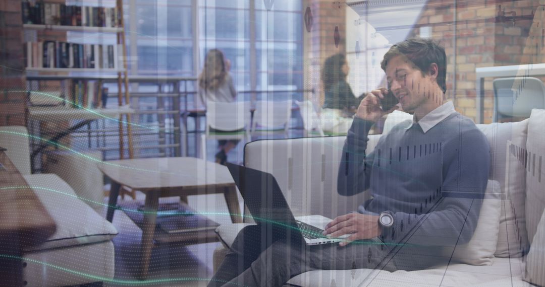 Professional Using Laptop and Phone in Modern Office Lounge