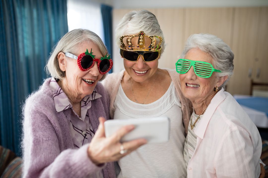 Senior women wearing novelty glasses taking selfie through smart phone - Free Images, Stock Photos and Pictures on Pikwizard.com