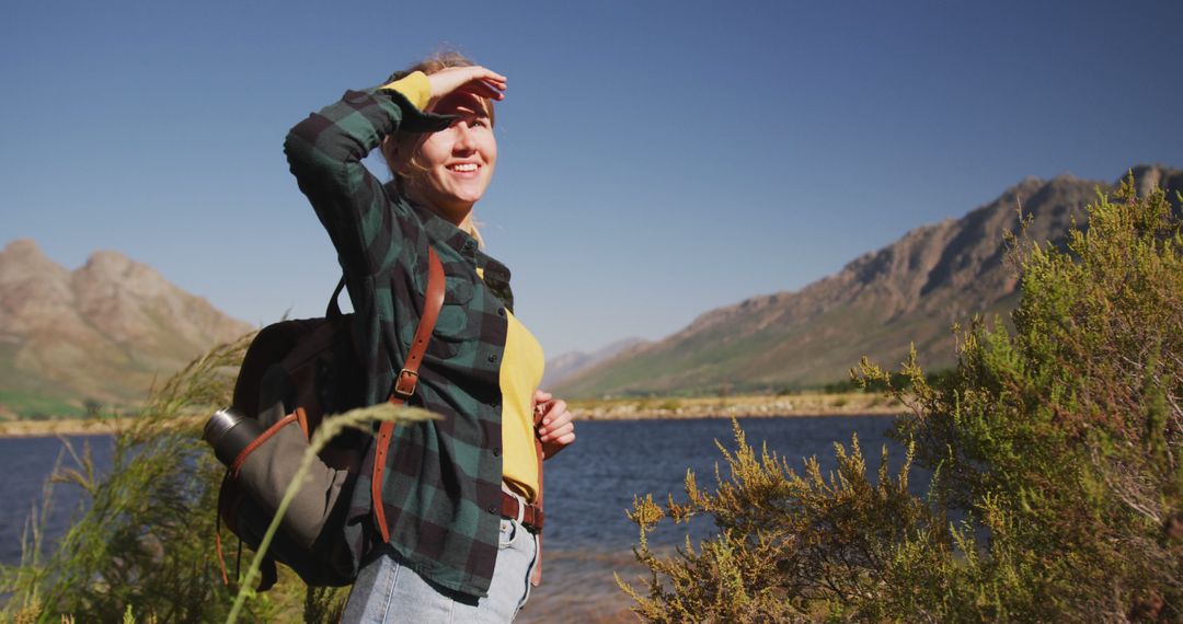 Adventurous Woman Hiking Near Serene Lake with Mountain Views - Free Images, Stock Photos and Pictures on Pikwizard.com