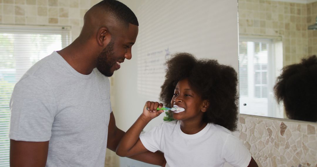 Father Encouraging Daughter Brushing Teeth Together at Home - Free Images, Stock Photos and Pictures on Pikwizard.com