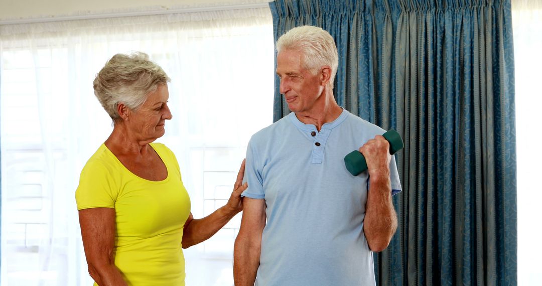 Trainer Assisting Senior Citizens in Home Fitness Routine
