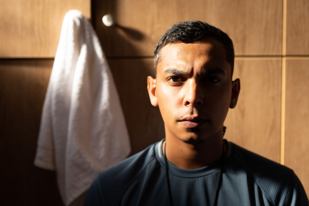 Focused Biracial Male Football Player in Changing Room - Free Images, Stock Photos and Pictures on Pikwizard.com