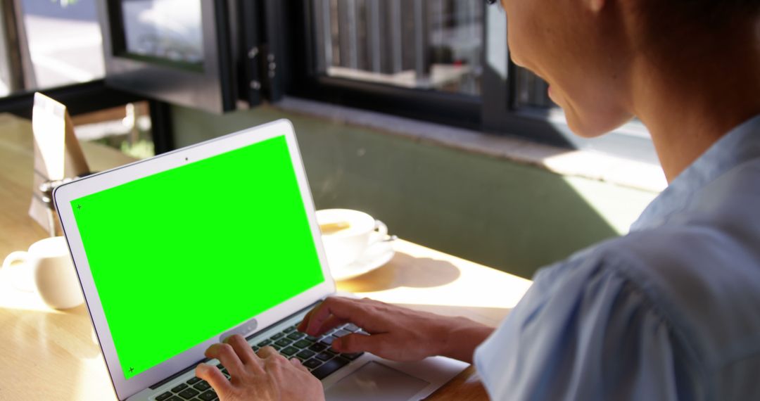 Woman working on laptop with green screen at coffee shop - Free Images, Stock Photos and Pictures on Pikwizard.com