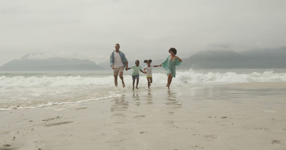 Happy family running on beach at seaside vacation - Free Images, Stock Photos and Pictures on Pikwizard.com