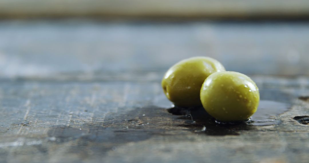 Two Fresh Green Olives with Dew on Wooden Table - Free Images, Stock Photos and Pictures on Pikwizard.com